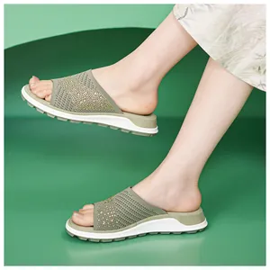Detailed view of women's olive green knitted flat slide sandals with sparkling rhinestones