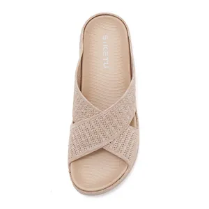 Macro view of women's beige fly-knit platform slide sandal with cross-strap detail