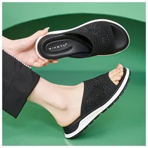 Detail view of breathable flyknit upper with sparkling rhinestones on black flat sandals
