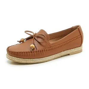 Detailed side view of brown faux leather loafers with bow detail and espadrille sole