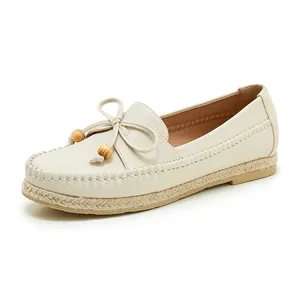 Detailed view of beige pebbled leather loafers with wooden bead bow and jute-wrapped sole