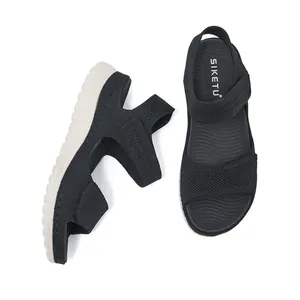 Detailed view of black breathable knit sports sandals with thick white soles and velcro straps