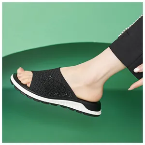 Close-up view of comfortable black fly-knit slide sandals with sparkling rhinestone details