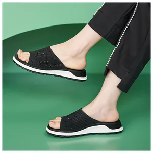 Detailed view of women's black fly-knit slippers with sparkling rhinestone embellishments