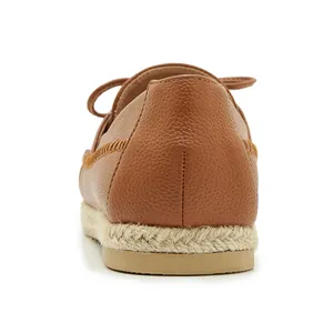 Detailed rear view of brown textured leather shoes with braided rope sole finish.