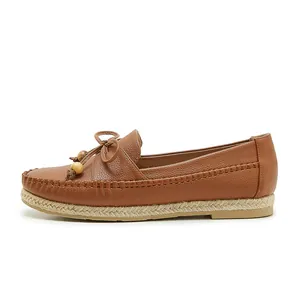 Side view of brown leather loafer with bow, wooden beads and woven midsole details
