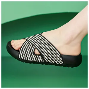 Close-up side view of a stylish thick-soled slide with black and white woven straps.