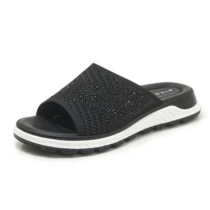 Detail shot of black flyknit slide sandals with sparkling rhinestone embellishments.
