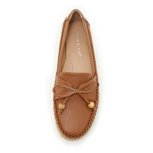 Overhead view of brown pebbled leather loafers with decorative bow and beads detail.