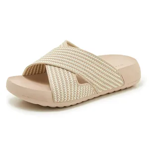 Close-up of beige platform slide sandal featuring a cross-knit strap and soft sole.