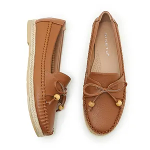 Detailed view of comfortable brown leather moccasins with stylish bow and wooden beads