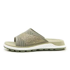 Detail view of breathable flyknit slide sandal with gold rhinestone embellishments.