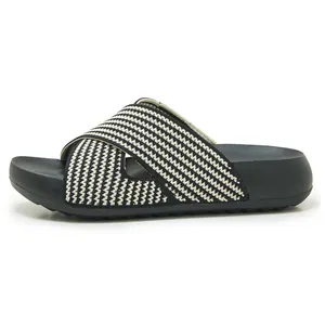Side profile detail of black and white cross-strap platform slide sandals