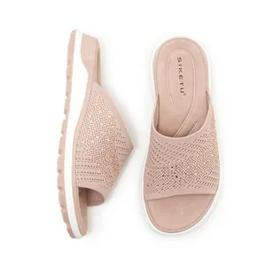 Close-up view of pink fly-knit slides with sparkling rhinestone accents for women