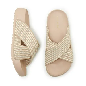 Detailed view of beige platform slides with crisscross knit straps and lightweight soft sole