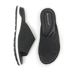Close-up of black flyknit slide sandals with sparkling rhinestone embellishments