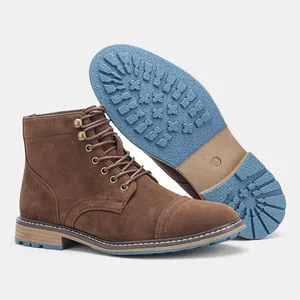 Vista detallada de botas de gamuza marrón para hombre con suela de goma azul antideslizante.