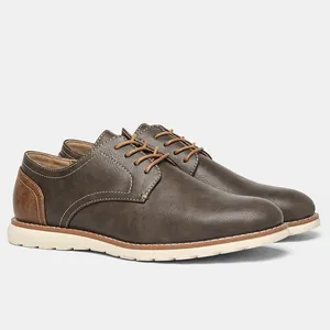 Vista detallada lateral de zapatos Oxford vintage para hombre en cuero marrón con suelas blancas.