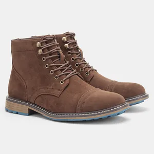 Detalle de las botas Martin de gamuza marrón para hombre con detalles en la suela azul.