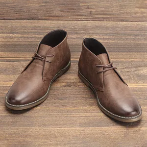 Primer plano de botas desert marrones vintage para hombre en suelo de madera