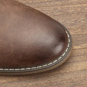 Detalle de la punta de la bota desert en cuero marrón retro con costuras blancas