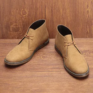 Botas desert chukka clásicas de ante caqui para hombre sobre fondo de madera cálida
