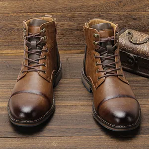 Vue détaillée de face de bottes en cuir marron vintage pour hommes sur fond bois