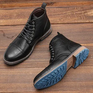 Vista detallada de botas Martin de cuero negro para hombre con suelas azules en madera