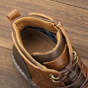 Close-up view showing the interior lining and metal eyelets of a retro brown leather Martin boot
