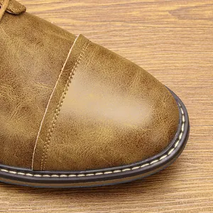 Macro view of vintage burnished leather texture and stitched toe on men's work boots.