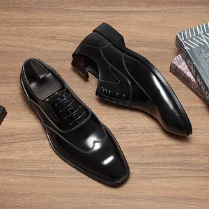 Chaussures richelieu en cuir noir avec embauchoirs en bois sur une surface en bois