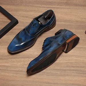 Détail de chaussures Oxford artisanales en cuir bleu patiné sur bois