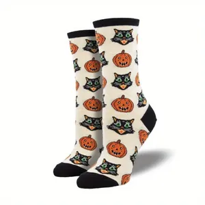 Detailaufnahme der Halloween-Socken mit lächelnden Kürbissen und schwarzen Katzenmotiven.