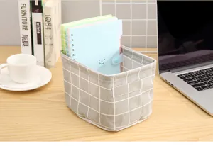 Macro view of grey grid fabric storage basket on wooden desk with office supplies
