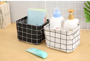 Close-up of cotton linen storage baskets in black and white grid patterns for desktop organizing