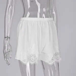 Vista detallada de pantalones cortos de satén blanco con encaje de pestañas fino