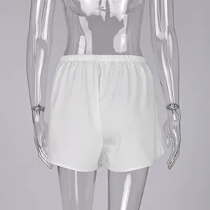 Detalle de la parte trasera de pantalones cortos de satén blanco para mujer en maniquí