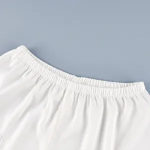 Primer plano del elástico en la cintura de shorts de satén blanco con encaje