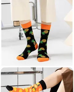 Vue détaillée de chaussettes en coton avec des motifs de fruits ananas et citron.