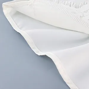 Primer plano de pantalones cortos de satén blanco con encaje delicado y costura fina.