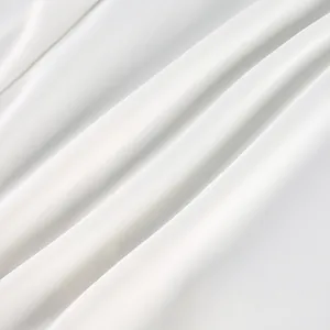 Primer plano de elegante tela de raso blanco con pliegues suaves y textura lisa
