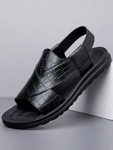 Nahaufnahme von stilvollen schwarzen Herren-Sandalen mit Krokoprägung und rutschfester Sohle