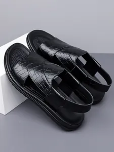 Nahaufnahme von schwarzen Herren-Sandalen mit stilvollem Krokodil-Muster