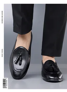 Detailaufnahme von hochwertigen schwarzen Herren-Quasten-Loafers zu professionellen Hosen