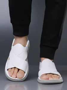 Nahaufnahme der weißen Herren-Sandalen mit gekreuzten Riemen und grauer Sohle