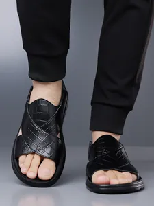 Detailansicht der schwarzen Herren-Sandalen mit Krokodilprägung und Kreuzriemen-Design