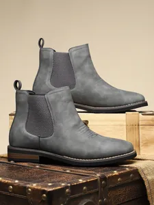 Detailed macro shot of grey men's Chelsea boots featuring elastic side panels.
