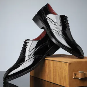 Dettaglio di scarpe brogue da uomo in pelle verniciata nera con motivi intagliati