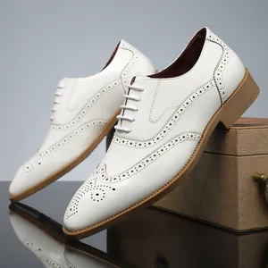 Dettaglio di scarpe Oxford brogue bianche con eleganti motivi traforati