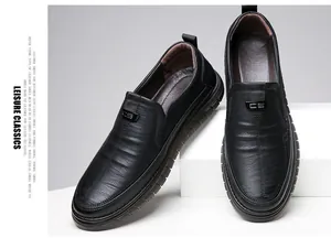 Detailed macro view of black slip-on leather loafers featuring a classic metal buckle